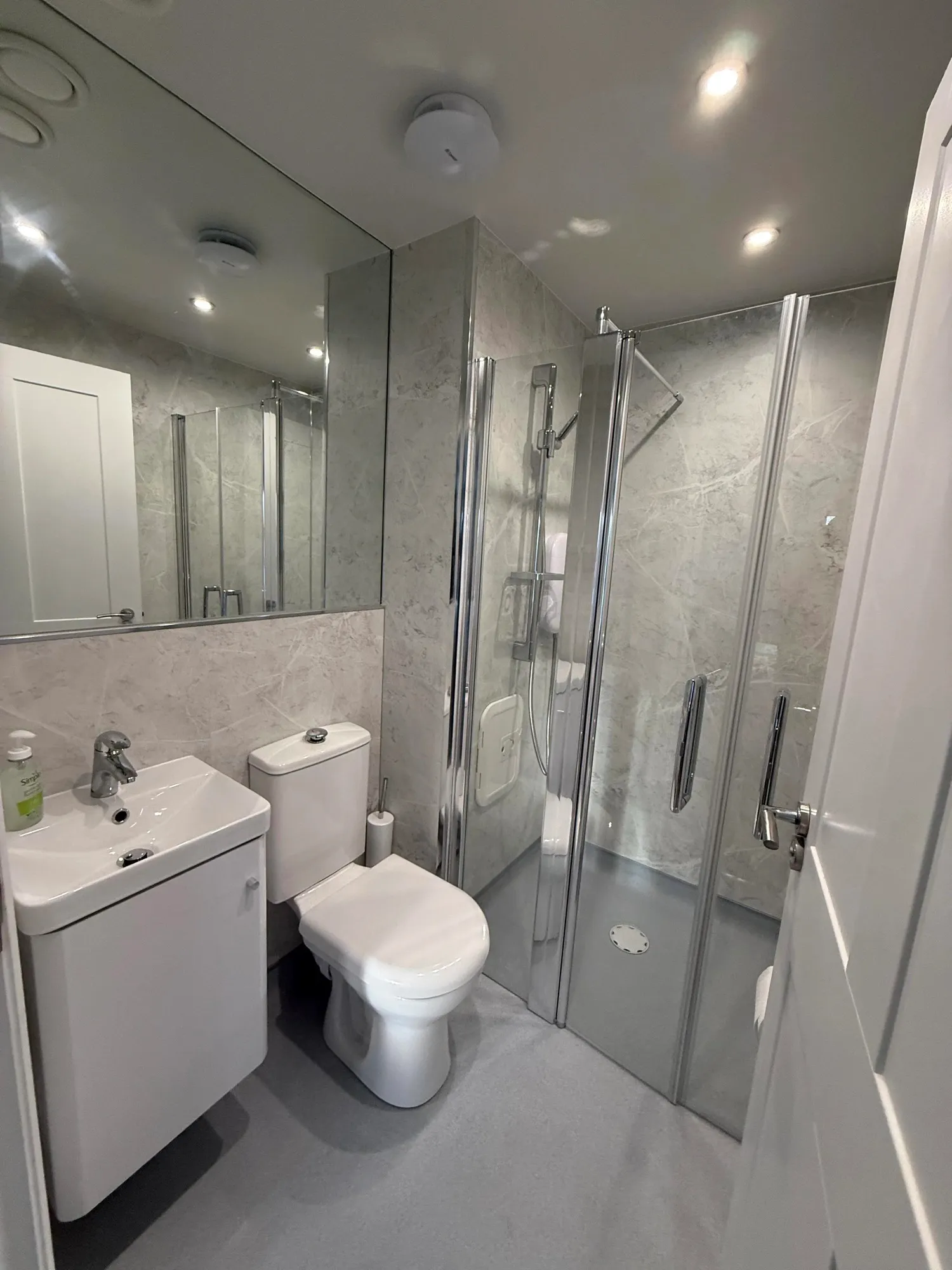 Grey marble-effect shower room with mirror and folding screen