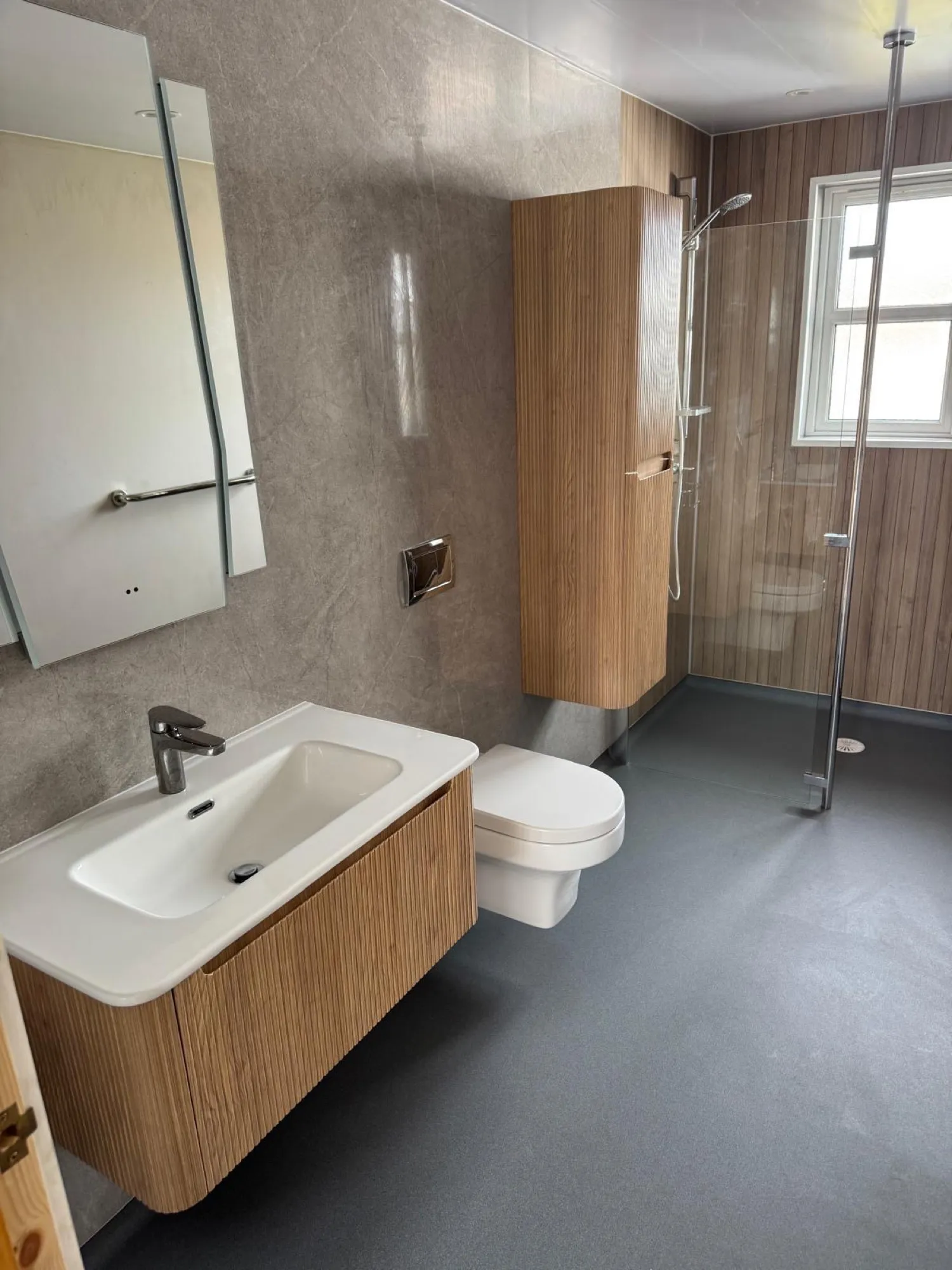 Vanity basin with walnut drawer units and the shower beyond
