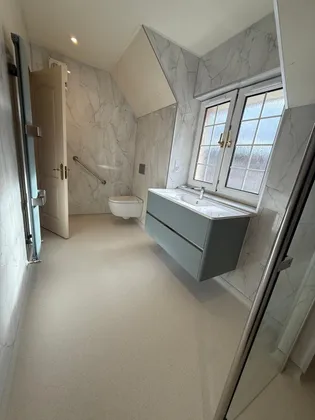 A finished attic shower room with a level-access tray
