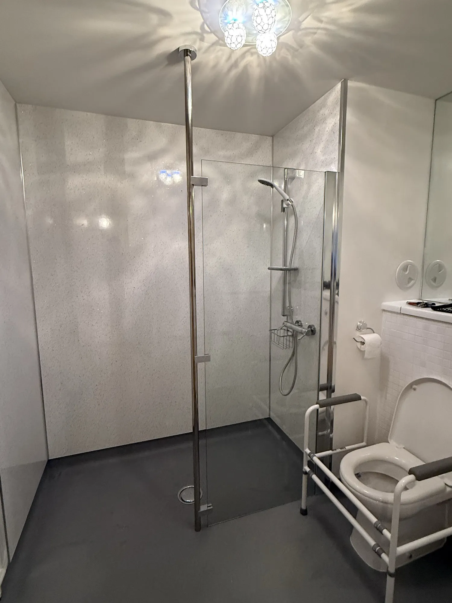 Wet room with a grey floor and low-profile shower tray