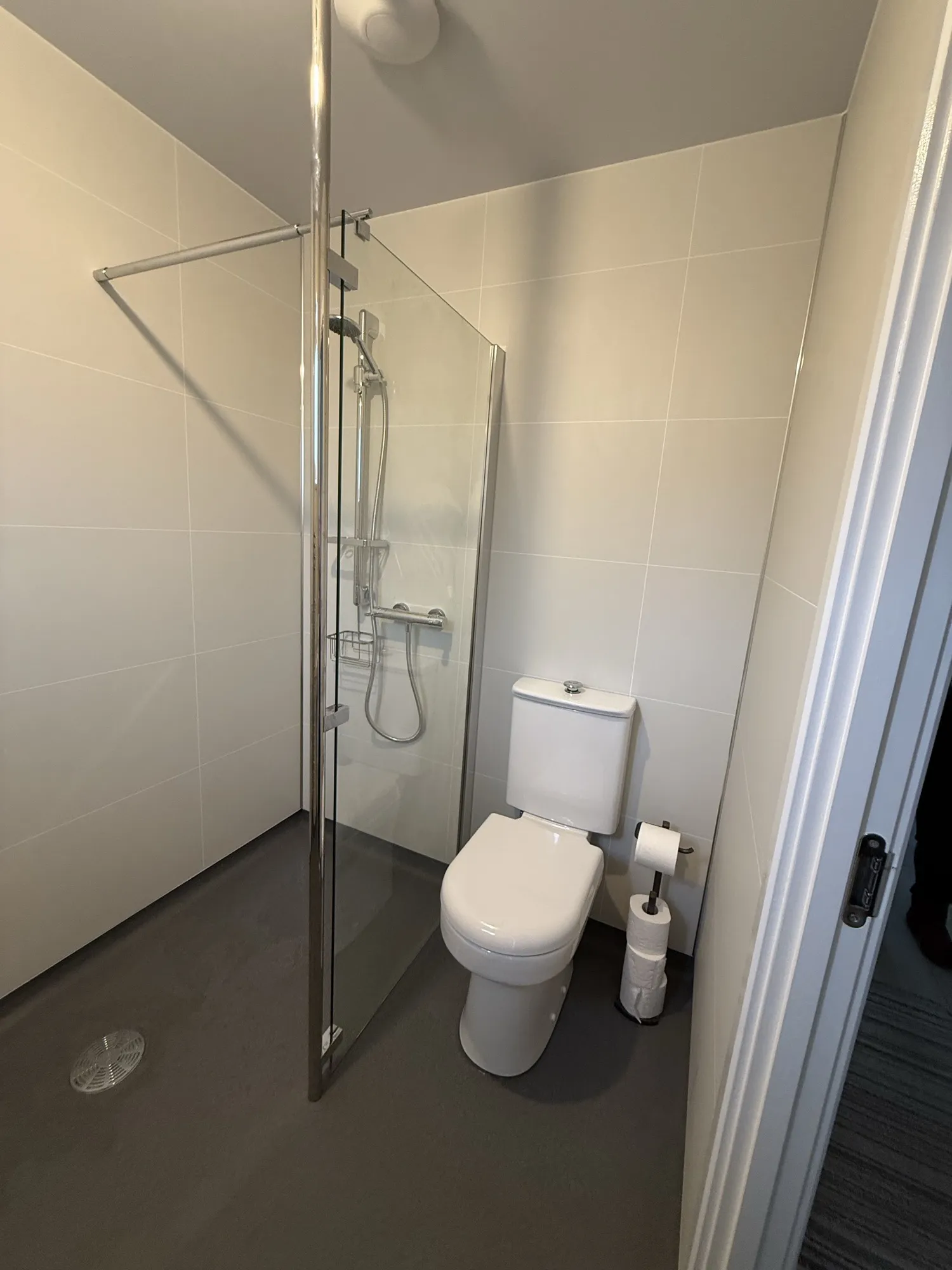 Walk-in shower with a glass panel beside the toilet