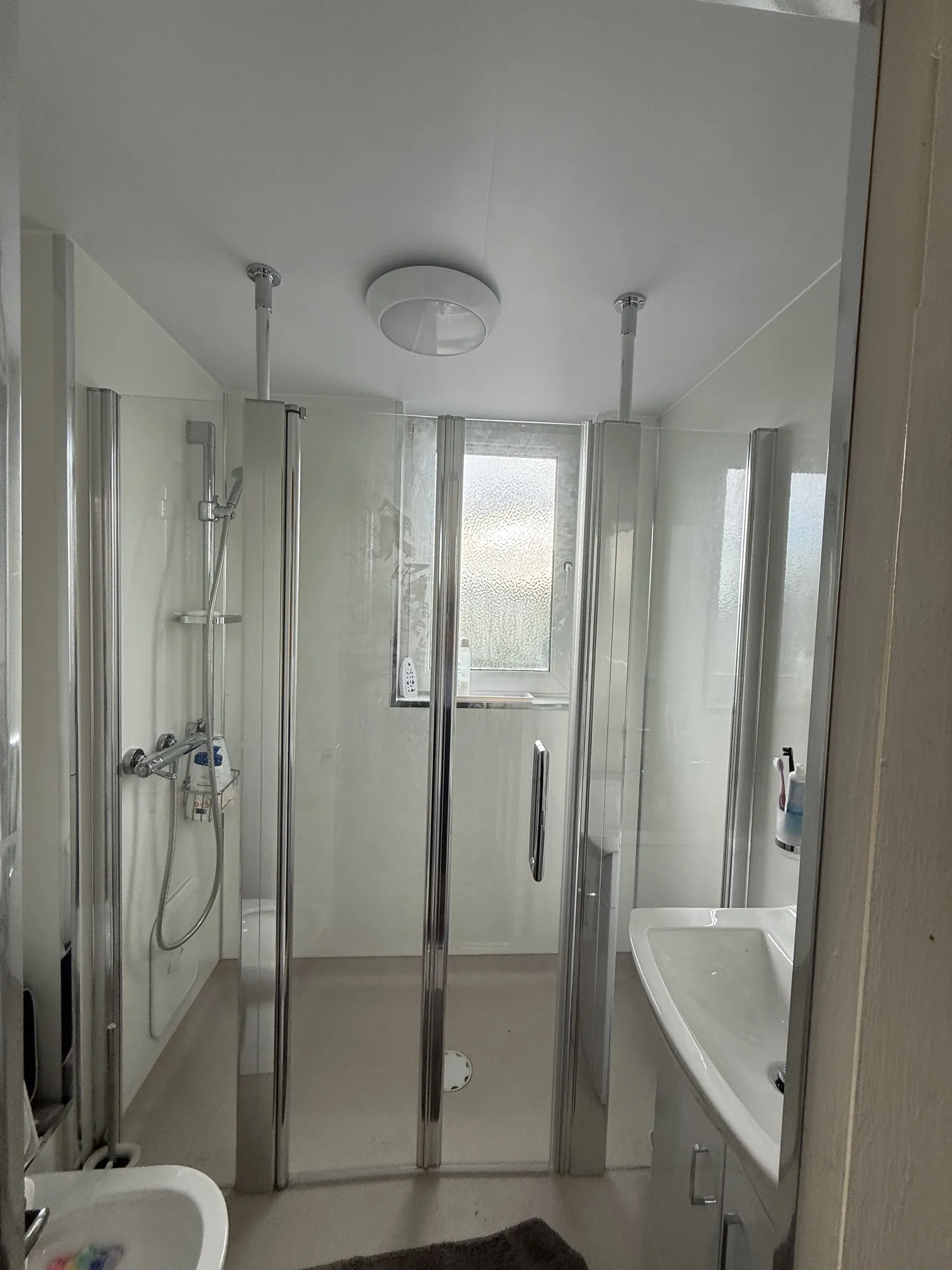 Twin glass shower screens in a marble-effect wet room