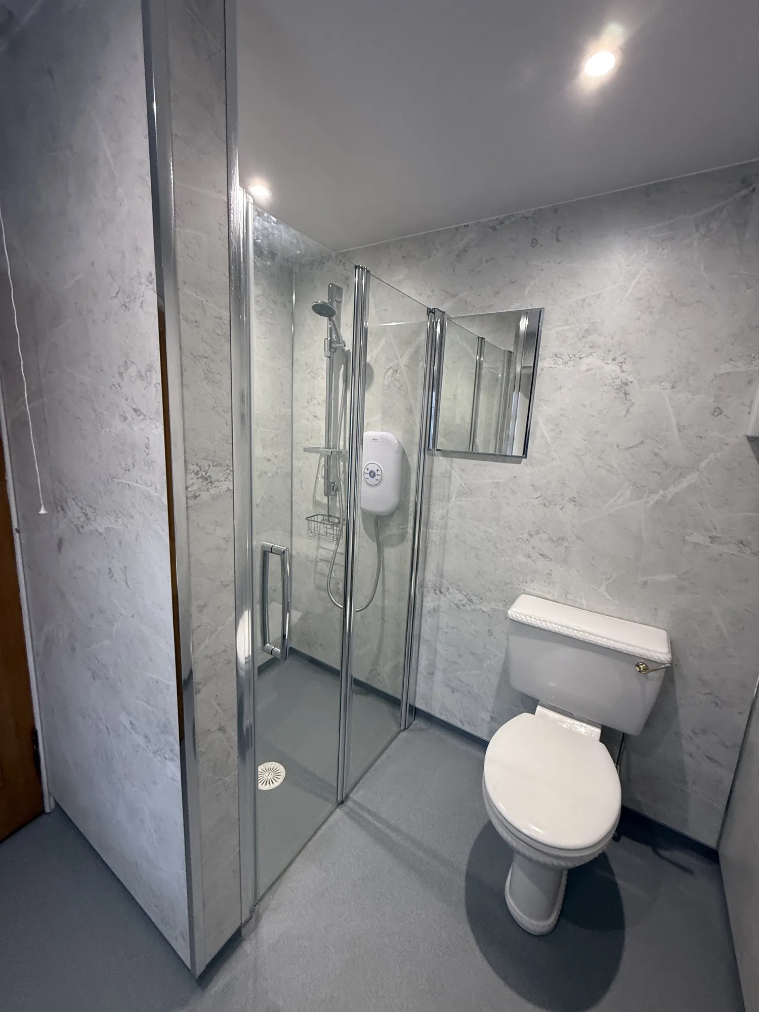 Shower room with grey stone-effect panels and toilet