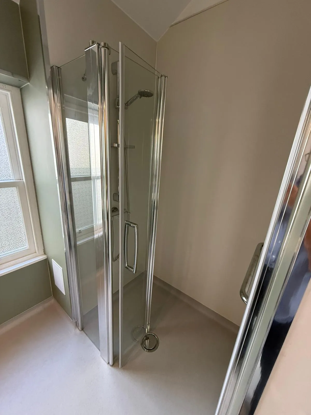 A compact level-access shower with a folding screen