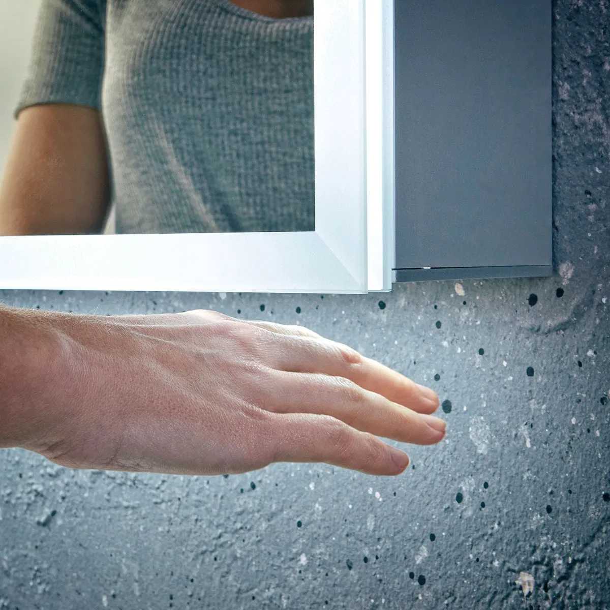The sensor control on an illuminated bathroom mirror cabinet