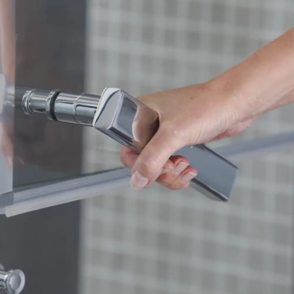 A hand operating a lever handle on a shower screen