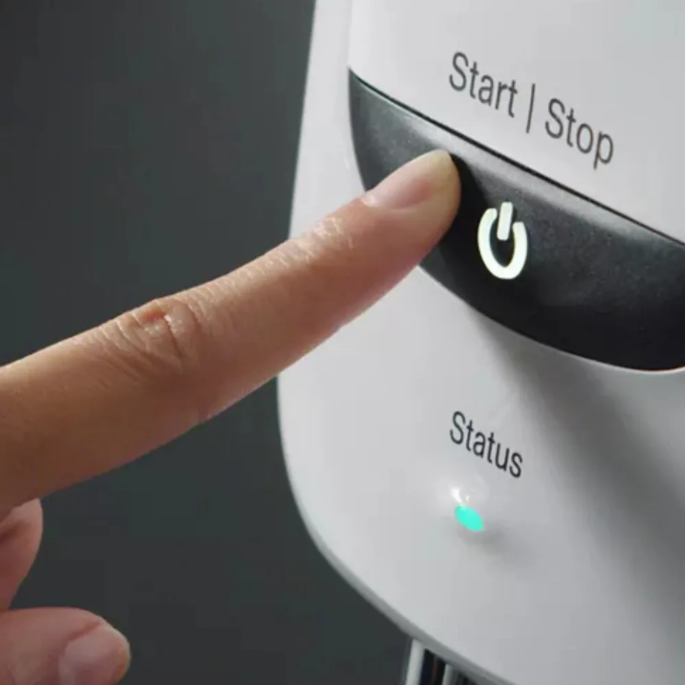 A finger pressing a clear shower start and stop button