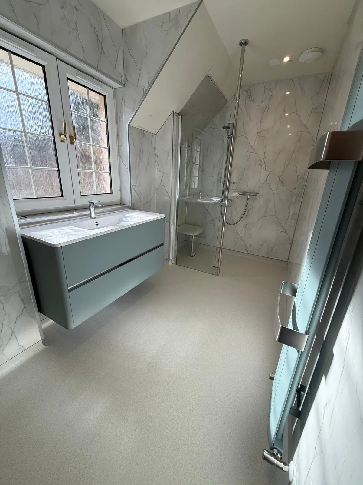 A completed level-access wet room with a spacious showering area